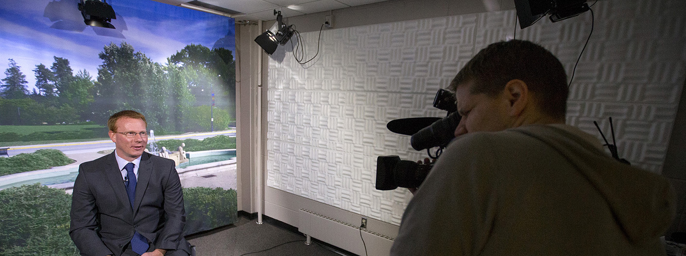 Videographer filming a professor in the live video studio.